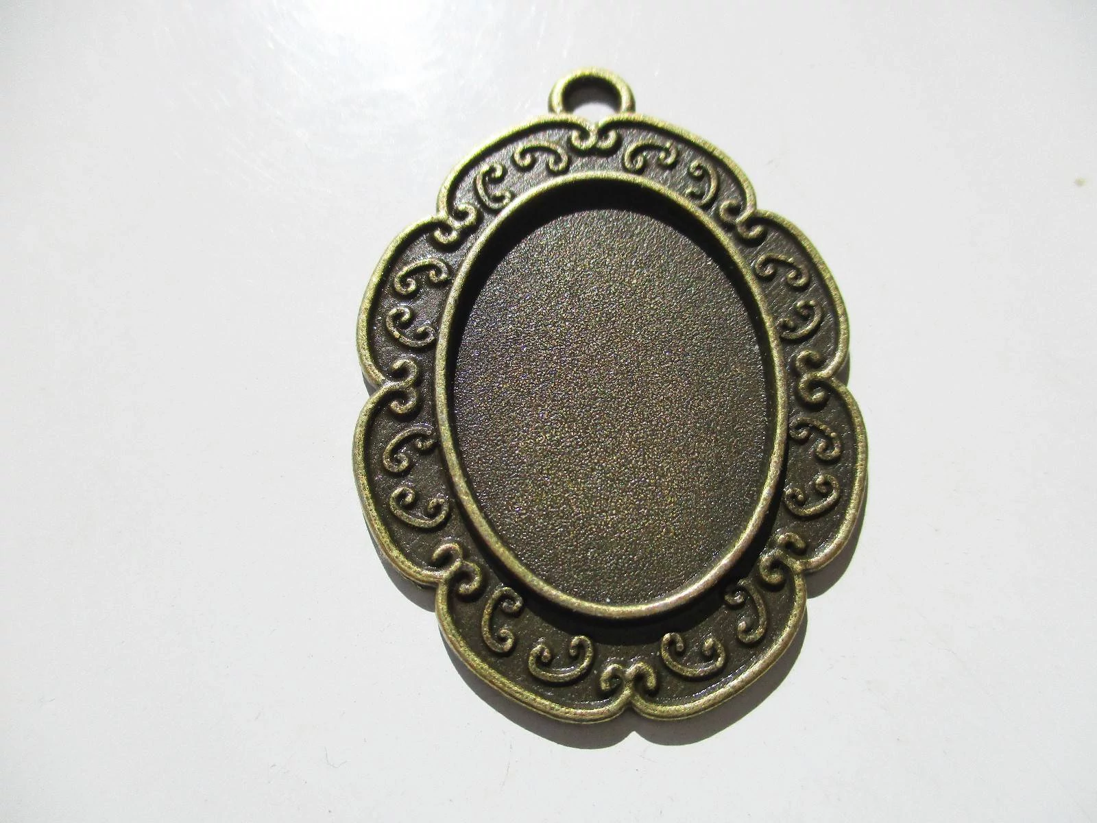 Díszes medálalap, antik bronz színű, 40x29 mm, 25x18 mm-es lencséhez