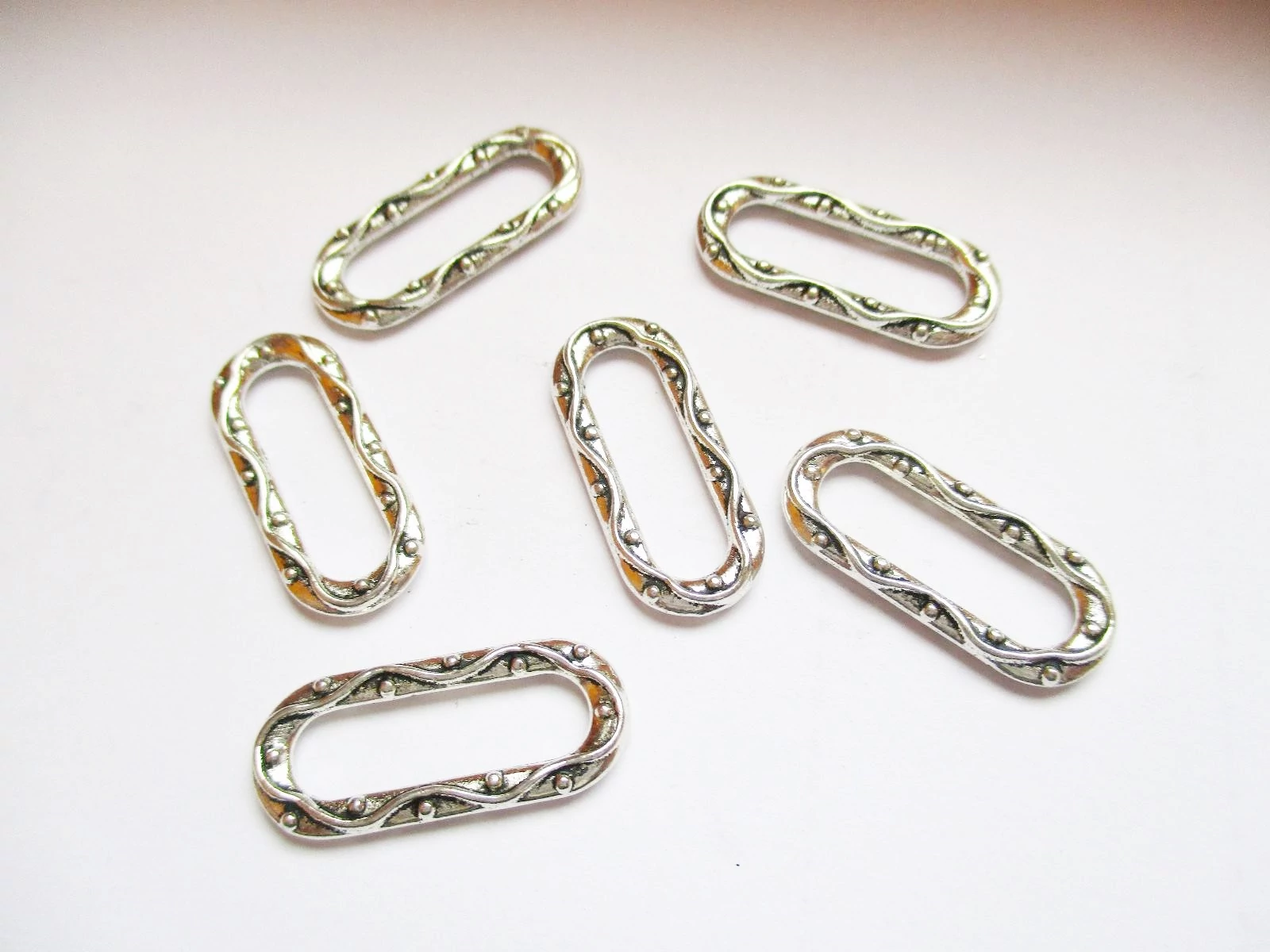 Díszes ovális összekötő, távtartó, antik ezüst színű, 20x9 mm