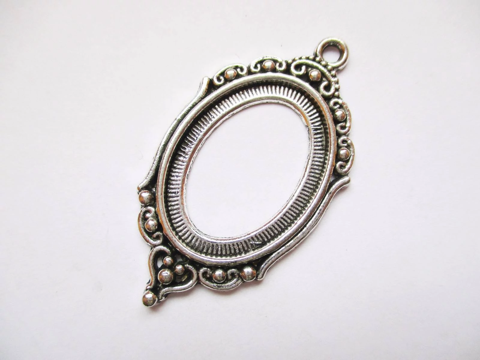 Ovális díszes medálalap, antik ezüst színű, 42x28 mm, 25x18 mm-es lencséhez