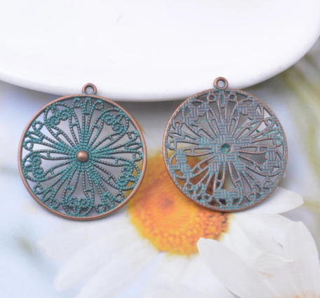Kerek, áttört medál, patina vörösréz színű, 33x30 mm