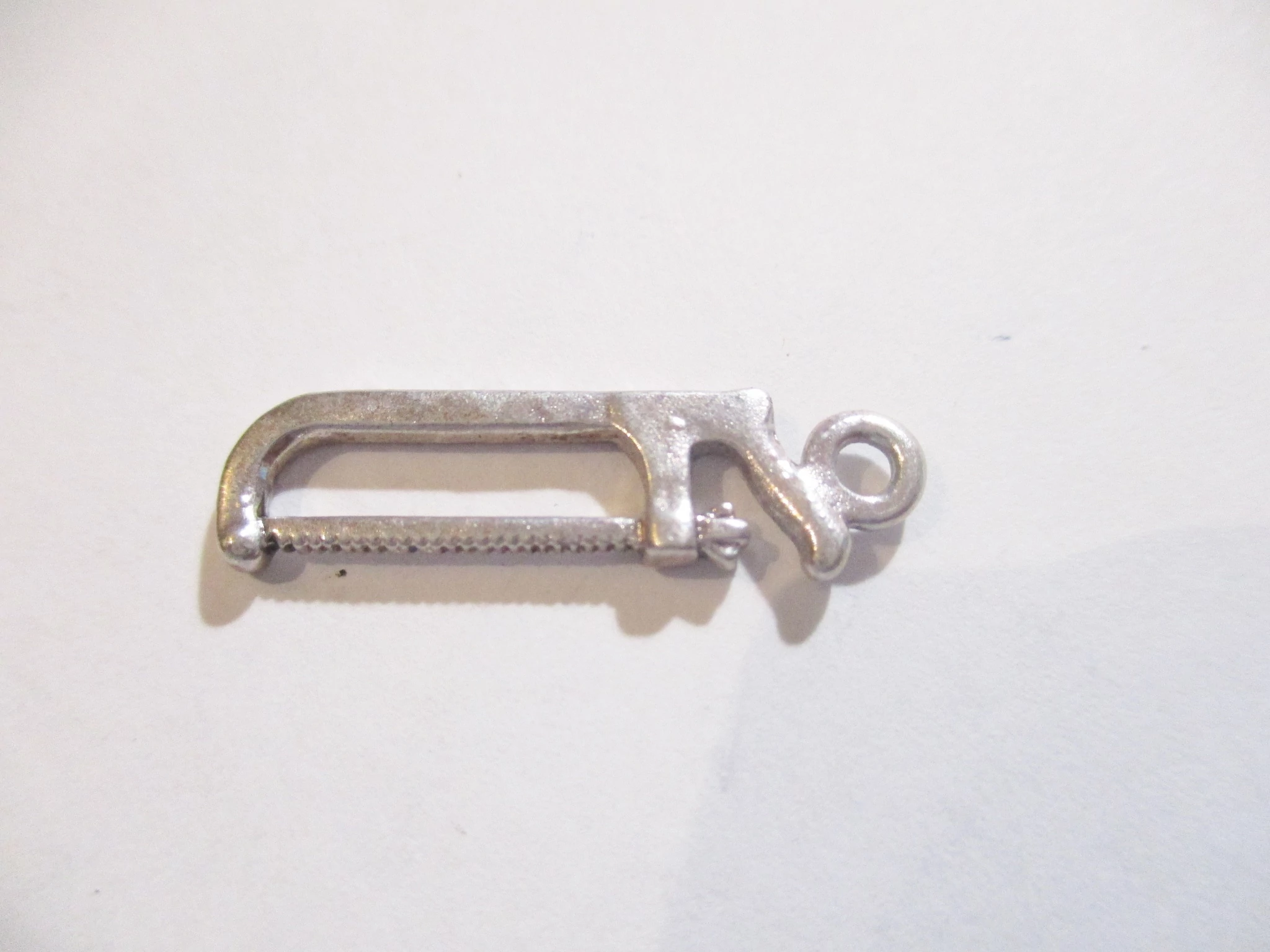 Fűrész, szerszám fityegő, medál, antik ezüst színű, 25x8 mm
